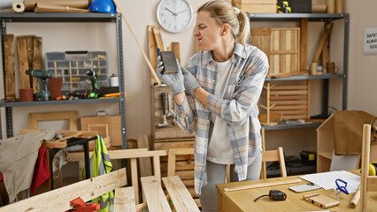 Blonde woman woodworker inspecting sandpaper frustration workshop