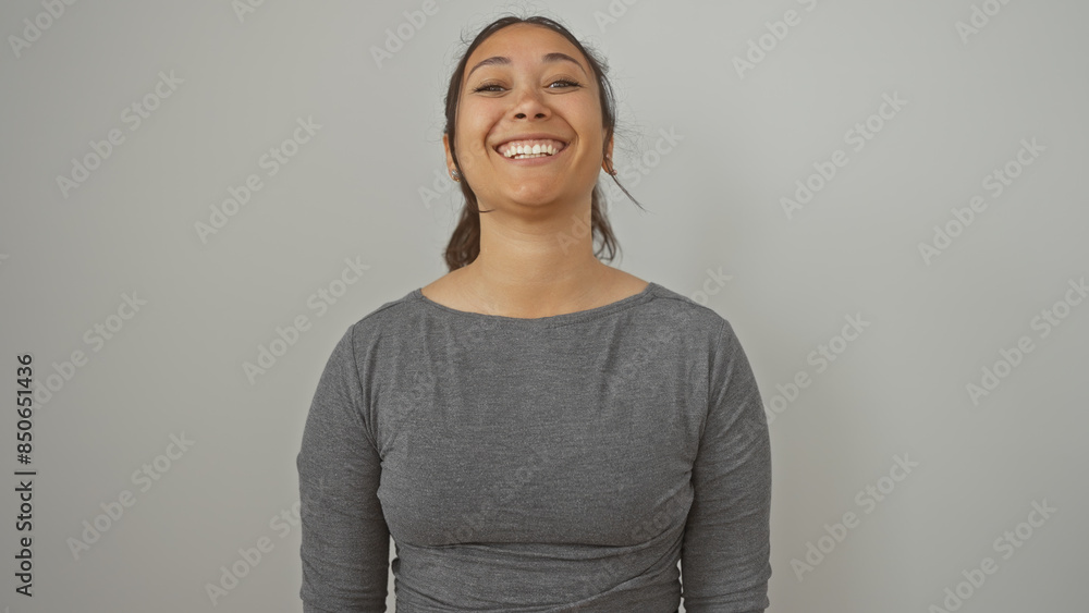 Wall mural A cheerful young hispanic woman with a beautiful smile standing against a white isolated background