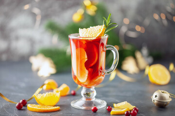 Mulled wine with apples, oranges and spices in a glass on the Christmas decoration. Winter alcoholic drink