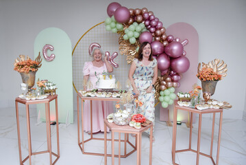 decoration for party, birthday party, mother and daughter, birthday people smiling, elderly woman's...