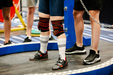legs powerlifter in long socks, elastic wrap bandage on knees