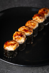 Baked sushi on a black plate