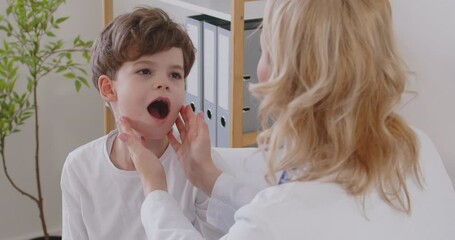 Dentist doctor is carefully examining a child, young boy patient at a clinic, providing dentistry healthcare and quality treatment. Regular medical dental check ups for children teeth.