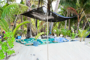 Tranquil beach setup with shade, cushions, and relaxing atmosphere, ideal for peaceful getaway