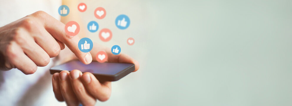Social media and digital online communication concept, man using smartphone with likes icons on social media. Banner background.