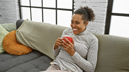 Smiling woman relaxing with coffee on couch in a cozy modern living room