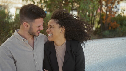 A smiling couple embracing outdoors, showing love and connection in a natural park setting.