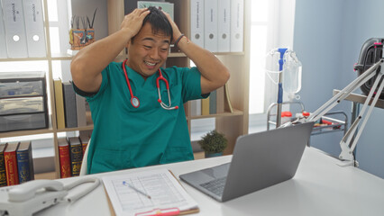 Obraz premium An attractive young asian man in a clinic wearing a stethoscope looks stressed while working on a laptop at his veterinary workplace.