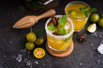Fresh summer orange mojito with tangerine orange, mint and ice on black background