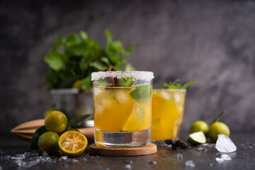 Fresh summer orange mojito with tangerine orange, mint and ice on black background