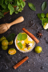 Fresh summer orange mojito with tangerine orange, mint and ice on black background