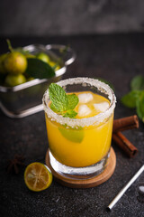 Fototapeta premium Fresh summer orange mojito with tangerine orange, mint and ice on black background