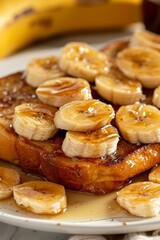 Close Up of Sweet French Toast With Banana Slices and Syrup