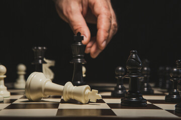 Close up of hand holding chess on chess board