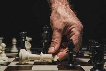 Close up of hand holding chess on chess board