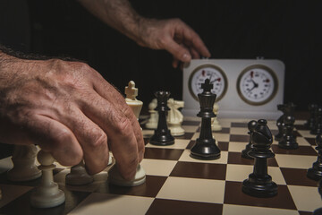 Close up of hand holding chess on chess board