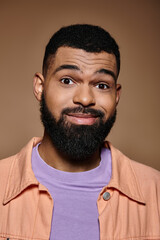 Obraz premium Close-up of stylish African American man with beard in vibrant setting.