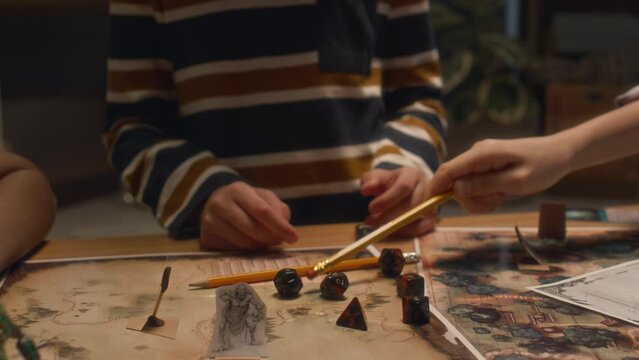 Midsection shot of unrecognizable children choosing dice before playing table game at home in evening