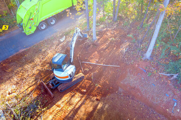 An uprooted tree is cleared for construction by tractor during construction