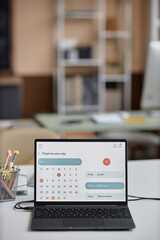 Vertical shot of online calendar page on laptop screen for schedule planning. Personal and business organizer, copy space