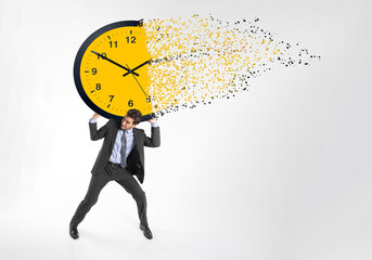 A diligent businessman in a suit drags a dissolving clock on a white background. Time wasting...