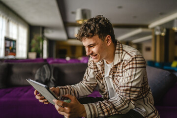 Young adult boy use digital tablet for online chat or explore internet