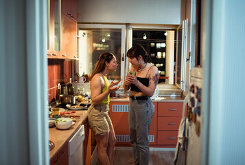 Young lesbian couple arguing in the kitchen at night