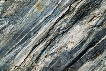 Detailed close-up of marble rock showcasing its natural striations and texture. The image captures the intricate patterns and colors within the stone, highlighting the beauty of natural geology.