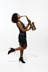 Chic Musician. Young African-American woman in trendy outfit playing saxophone isolated on white...