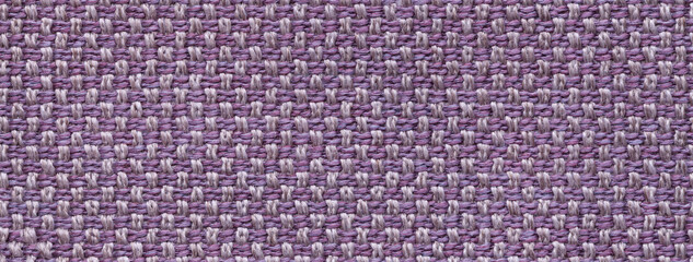 Texture of violet color background from woven textile material with wicker pattern, macro. Vintage purple fabric