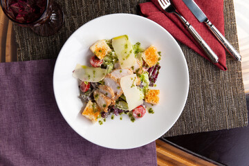 Salad with chicken fillet and cheese in a plate.