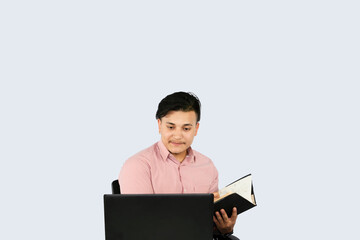 Front Desk Male Receptionist with Mobile Device Laptop and Notepad gives expressions and gestures of happy in Office Environment