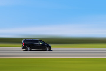 Black passenger minibus, minivan is driving on the street with blurred background at speed. Car with passenger transportation concept and free space for text, copy space. Taxi, transfer shuttle