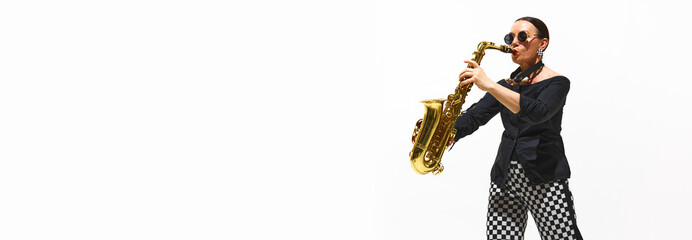 Woman, musician in a black and white outfit plays the saxophone with vibrant energy isolated on white background. Concept of music, festival, concert, talent, performance. Banner. Copy space for ad