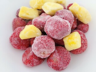 Frozen strawberries and pineapple cubes.