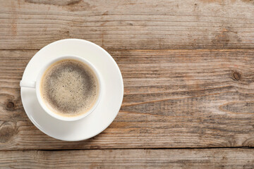 Tasty coffee in cup on wooden table, top view. Space for text