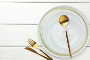 Stylish setting with cutlery and plate on white wooden table, flat lay. Space for text