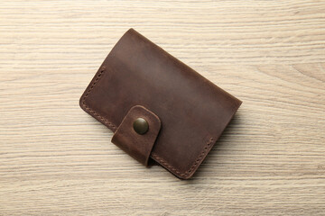 Leather business card holder on wooden table, top view