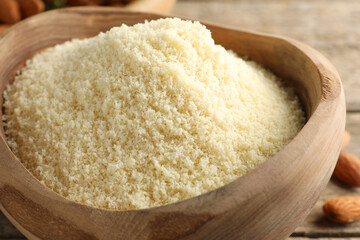 Fresh almond flour in wooden bowl on table, closeup