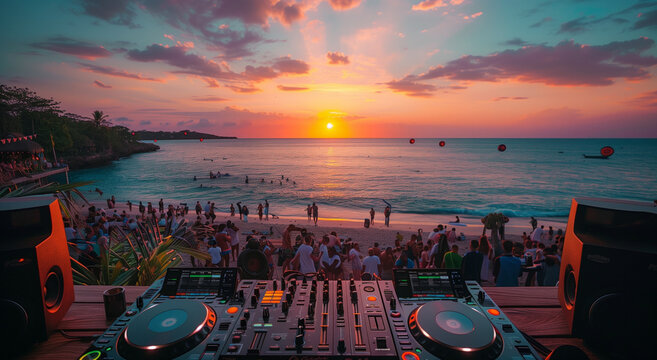 A close-up shot of hands on turntables, with people dancing in soft focus behind at sunset during an outdoor party. A photo of DJ equipment on the beach with a sunset and crowd in the background. 