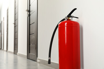 Fire extinguisher on floor in hall, space for text