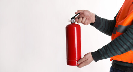 Man with fire extinguisher on light background, closeup. Space for text
