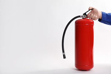Man with fire extinguisher on white background, closeup. Space for text