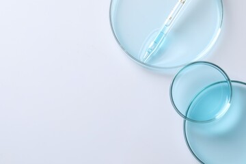 Measuring pipette and petri dishes on white table, flat lay. Space for text