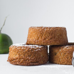 A stack of mini vanilla cakes, vanilla bundlette stacked on a white background, homemade small vanilla bundt cakes