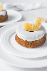 Iced mini bundt cake on a white plate, vanilla citrus bundlette on a plate, small vanilla bundt cake with an icing glaze