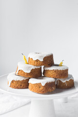 Iced mini bundt cakes stacked on a white plate, glazed vanilla and citrus bundlettes on a plate, small vanilla bundt cake with an icing glaze