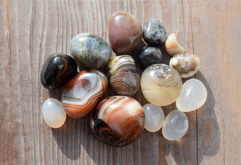 Healing crystals on an old wooden background. Botswana agate. Multi-colored gems, minerals. Agates...