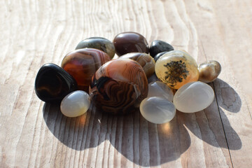 Obraz premium Healing crystals on an old wooden background. Botswana agate. Multi-colored gems, minerals. Agates of different sizes.
