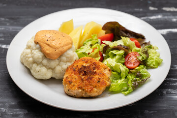 Fried chicken meatballs with boiled vegetables on white plate